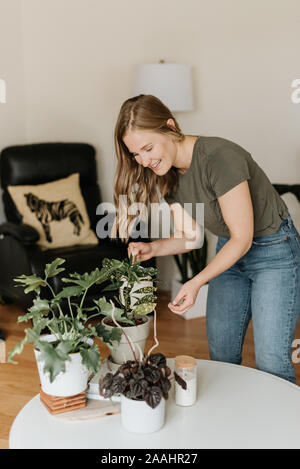 Frau Bewässerung Haus Pflanzen Stockfoto