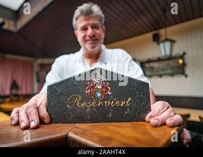 11 November 2019, Hessen, Frankfurt/Main: Götz Elsässer, Vermieter der traditionellen Restaurant 'Grauer Bock" im Stadtteil Sachsenhausen, Stände mit einer 'reserviert' Zeichen in seinem Restaurant. Tabellen sind hier schon Monate im Voraus reserviert, oft große Gruppen kommen. Umso ärgerlicher, wenn die Gäste weg ohne Stornierung Ihrer Reservierung. Weil immer mehr Gastronomen in Frankfurt sind solche Erfahrungen, unentschuldigtes Fehlen könnte bald teurer werden. Viele Gastwirte denken über so genannte "No-Show-Gebühren". Foto: Frank Rumpenhorst/dpa Stockfoto