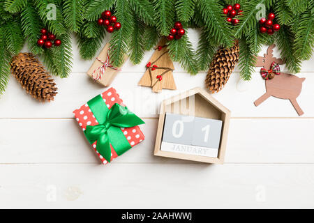 Blick von oben auf die Tanne, Weihnachtsschmuck, Geschenk und Kalender auf Holz- Hintergrund. Der erste Januar. Neues Jahr Konzept. Stockfoto