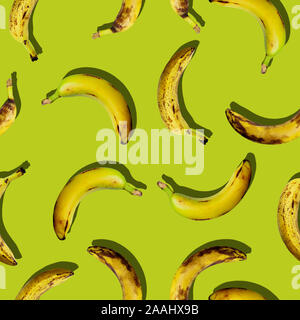 Farbenfrohe und kreative nahtlose Obst Muster von organischen hässlich reife Frucht Bananen auf grüne Farbe Hintergrund im Pop-Art-Stil. Moderne tropische Abstract Stockfoto