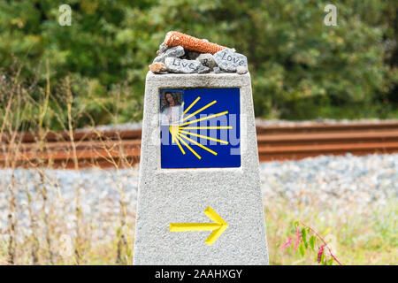 Gelbe Jakobsmuschel, touristische Symbol des Camino de Santiago, der die Richtung auf Camino Norte in Spanien. die Spalte mit den Felsen, die Unterschrift auf dem Weg zu Stockfoto