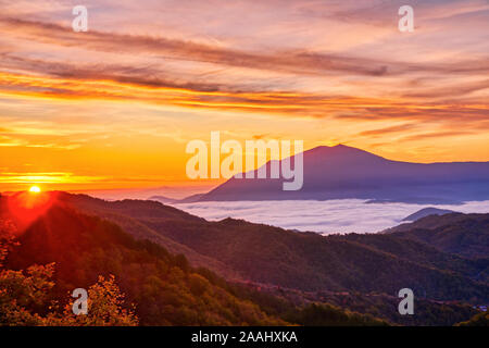 Erstaunlich Sonnenaufgang über neblige Landschaft. Malerischer Blick auf Nebligen Morgen Sky mit der aufgehenden Sonne über dem nebligen Wald. Rhodopen. Xanthi Thrakien, Griechenland Stockfoto