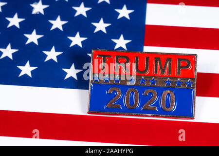 London, Großbritannien - 21 November 2019: ein Trumpf 2020 Präsidentschaftswahlkampf pin Badge, dargestellt über die Flagge der Vereinigten Staaten von Amerika. Stockfoto