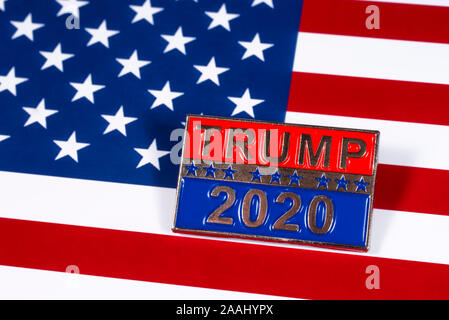 London, Großbritannien - 21 November 2019: ein Trumpf 2020 Präsidentschaftswahlkampf pin Badge, dargestellt über die Flagge der Vereinigten Staaten von Amerika. Stockfoto