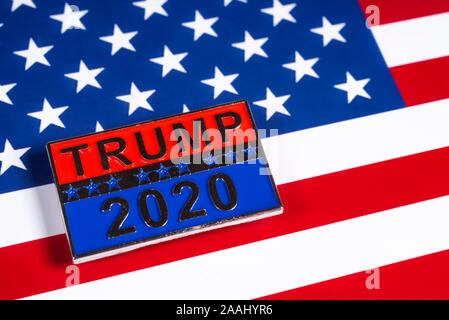 London, Großbritannien - 21 November 2019: ein Trumpf 2020 Präsidentschaftswahlkampf pin Badge, dargestellt über die Flagge der Vereinigten Staaten von Amerika. Stockfoto