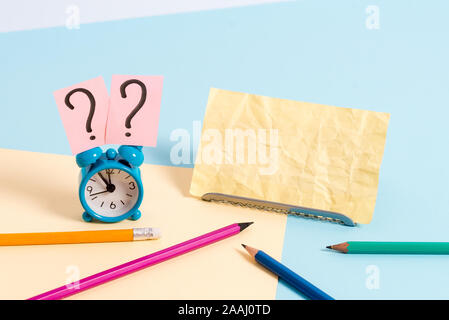 Mini Größe Wecker neben stationären platziert geneigt auf hellen Hintergrund Stockfoto