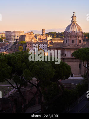 Panoramablick auf die Stadt Rom bei Sonnenuntergang, mit Kuppeln von Kirchen und dem Kolosseum Stockfoto