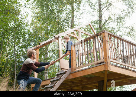 Vater und Sohn bauen Baumhaus im Garten Stockfoto