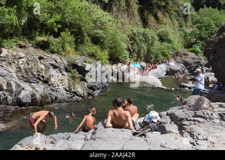 CURRAL DAS FREIRAS, Madeira, Portugal - August 2019: Übersicht über die Einheimischen baden in 'Poco dos Chefes "natürliche felsigen Strand in Curral das Freiras, Stockfoto