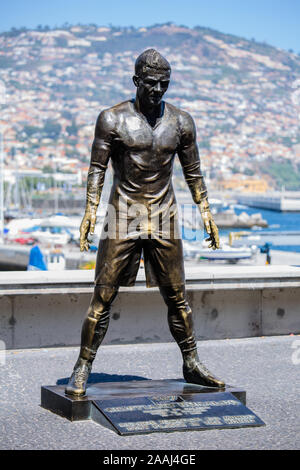 FUNCHAL, Madeira, Portugal - NOVEMBER, 2019: Die Statue von Cristiano Ronaldo vor CR7 Museum mit Stadt Funchal als Hintergrund Stockfoto