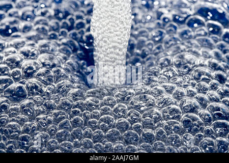 Ein Wasserstrahl erzeugen Blasen Stockfoto