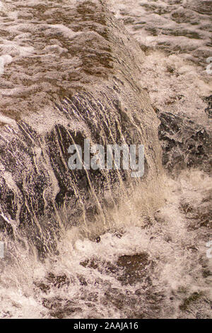 Wasser Kaskadierung über Wehr Schritte auf Canal Helling, blur unscharf Bewegungs- und freeze frame von Wassertröpfchen für Hintergrund tectures und Layer Effe Stockfoto