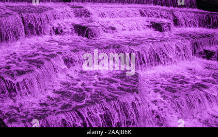 Wasser Kaskadierung über Wehr Schritte auf Canal Helling, blur unscharf Bewegungs- und freeze frame von Wassertröpfchen für Hintergrund tectures und Layer Effe Stockfoto
