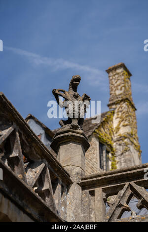 Stein Gargoyle Statue geschnitzt von Rock auf dem Dach einer Kirche in den Cotswolds England, Vereinigtes Königreich. Stockfoto