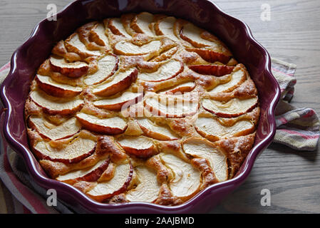 Apfelkuchen in einer Keramikschale auf einer hölzernen Oberfläche. Stockfoto