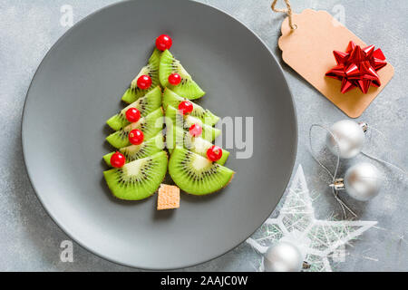 Kiwi Weihnachtsbaum mit Johannisbeeren, lustig Essen für Kinder. Weihnachten Lebensmittel Hintergrund. Stockfoto