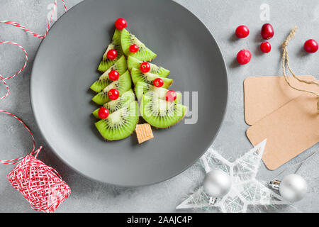 Kiwi Weihnachtsbaum mit Johannisbeeren, lustig Essen für Kinder. Weihnachten Lebensmittel Hintergrund. Stockfoto