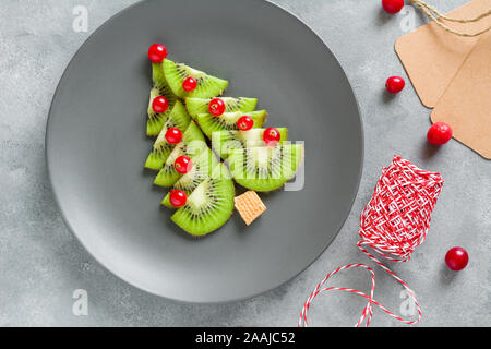 Kiwi Weihnachtsbaum mit Johannisbeeren, lustig Essen für Kinder. Weihnachten Lebensmittel Hintergrund. Stockfoto