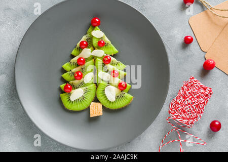 Kiwi Weihnachtsbaum mit Johannisbeeren, lustig Essen für Kinder. Weihnachten Lebensmittel Hintergrund. Stockfoto