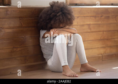 Biracial Vorschüler Mädchen weinen, sitzen auf dem Boden umgekippt Stockfoto