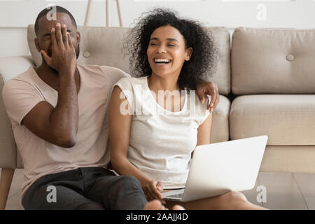 Lächelnd afrikanische amerikanische Paar lachen, lustige Video auf Laptop Stockfoto
