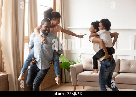 Afrikanische Eltern spielen mit Kindern sie tragen auf der Rückseite Stockfoto
