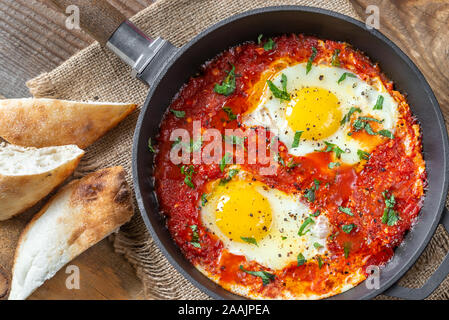 Shakshouka - pochierte Eier in Tomatensauce, in einer Pfanne serviert pan Stockfoto