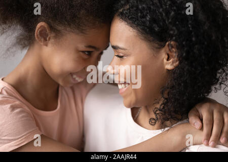 Glückliche Tochter umarmt Jungen Mutter closeup Gesichter Family Portrait Stockfoto