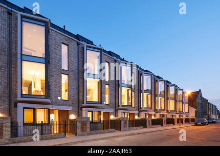 Schräge Erhöhung der modernen Terrasse mit beleuchteten Innenräumen. Warriner Gardens, London, Vereinigtes Königreich. Architekt: Kind Graddon Lewis, 2019. Stockfoto