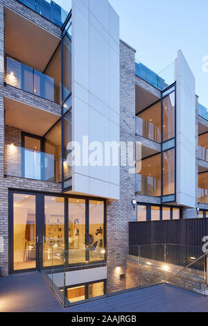 Die Außenfassade vom Balkon in der Abenddämmerung. Warriner Gardens, London, Vereinigtes Königreich. Architekt: Kind Graddon Lewis, 2019. Stockfoto