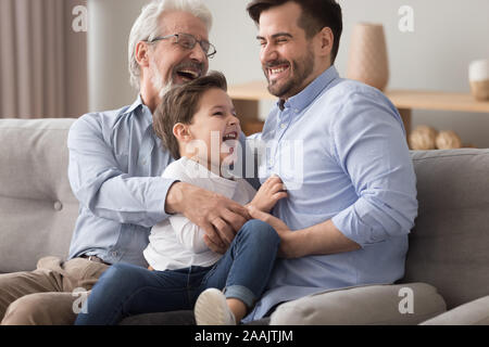 Gerne Großvater und Vater kitzeln little boy, Spaß Stockfoto