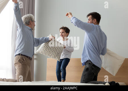 Gerne Großvater, Vater und niedlichen kleinen Sohn spielen Kissen Schlacht Stockfoto