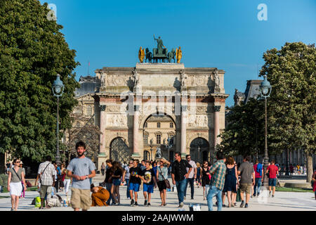 Eine Menge von Touristen vor dem Arc de Triomphe du Carrousel, am Eingang der Jardin de Tuileries gelegen, in der Nähe der wunderschönen Gebäude des t Stockfoto