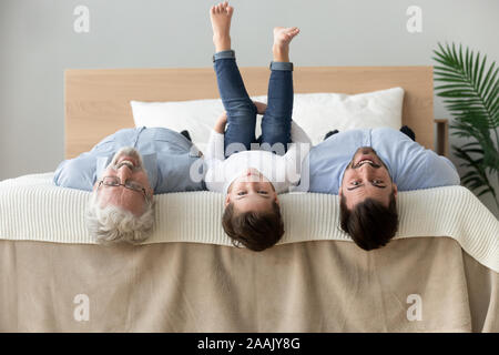 Drei Generationen von Männern auf dem Bett zusammen liegen, Spaß Stockfoto