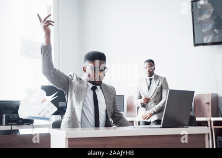 Zwei schöne und fröhliche afrikanische amerikanische Geschäftsmann Feier erfolgreich mit werfen Papier in Arbeitsbereich Stockfoto