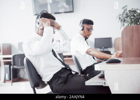 African American customer support Operator mit Freisprecheinrichtung die Arbeit im Büro Stockfoto