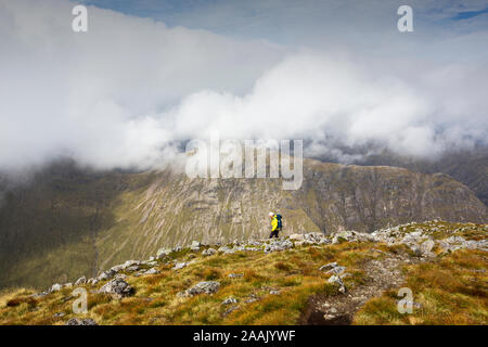 Eine weibliche Walker auf der Buachaiile Etive Mor Grat über Glen Coe, Schottland, UK, in Richtung Buachaille Etive Beag suchen. Stockfoto