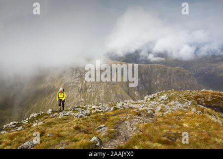 Eine weibliche Walker auf der Buachaiile Etive Mor Grat über Glen Coe, Schottland, UK, in Richtung Buachaille Etive Beag suchen. Stockfoto