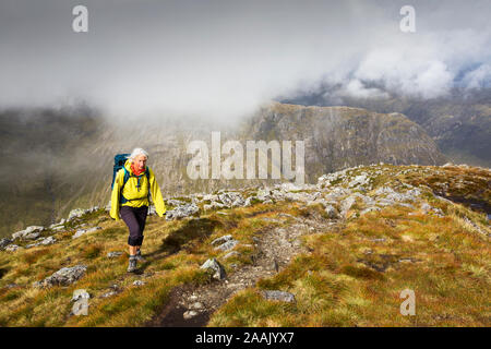 Eine weibliche Walker auf der Buachaiile Etive Mor Grat über Glen Coe, Schottland, UK, in Richtung Buachaille Etive Beag suchen. Stockfoto