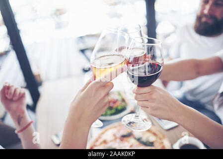 Freunde erhielt gemeinsam durch Tisch mit leckerem Essen mit Gläser Rotwein einen besonderen Anlass zu feiern. Stockfoto