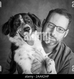 Studio Portrait von Mann mit Border Collie Mix Stockfoto