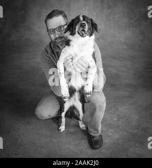 Studio Portrait von Mann mit Border Collie Mix Stockfoto