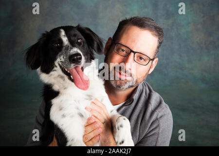 Studio Portrait von Mann mit Border Collie Mix Stockfoto