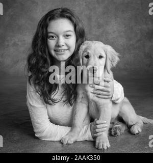 Studio Portrait von jugendlichen Mädchen mit Golden Retriever Welpen Stockfoto