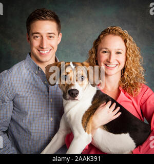 Studio Portrait von Paar mit gemischten Rasse Hund Stockfoto