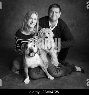 Studio Portrait von Paar mit Englisch Bulldogge und Mini Golden Doodle Stockfoto