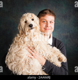 Mann hält Mini Goldendoodle Stockfoto