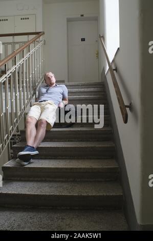 Junger Mann wartet im Stiegenhaus - Junger Mann im Treppenhaus warten Stockfoto