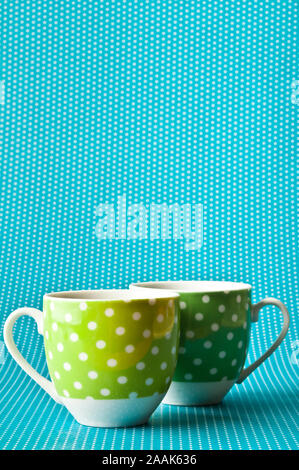 Zwei leere grüne Tassen Kaffee auf einem blauen Hintergrund Stockfoto
