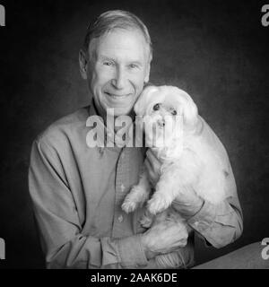 Portrait von älteren Mann mit Malteser Hund Stockfoto